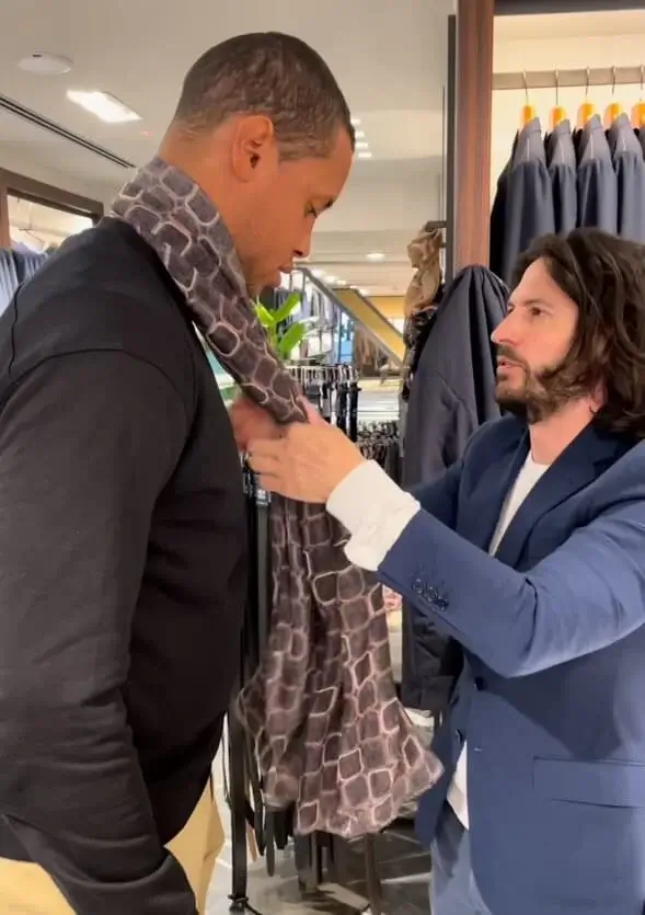 man trying on blazer and scarf
