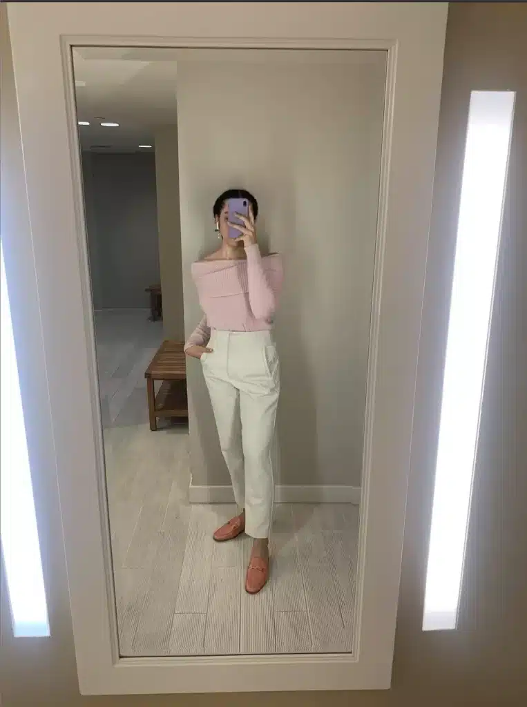 woman in pink off the shoulder sweater and white trousers