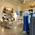 Reformation store with dresses on racks and purses on the wall