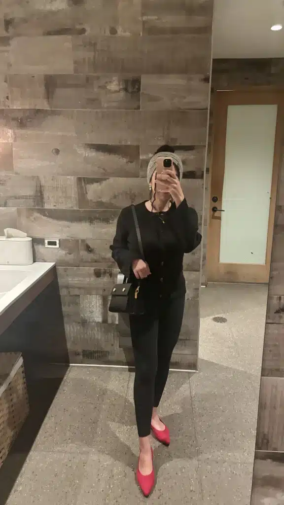 woman in black leggings and black cardigan with red flats and RSVP paris bag