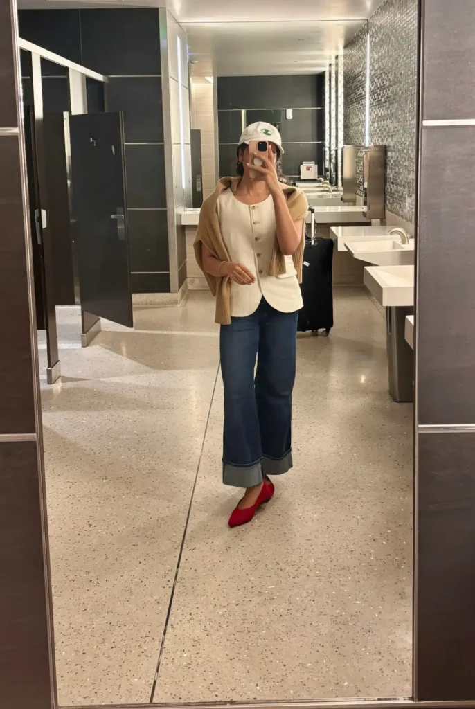 Woman in white linen vest and cuffed jeans dressing to look taller