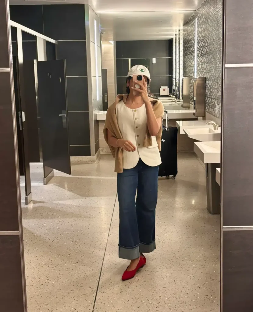 Woman in white linen vest and cuffed jeans dressing to look taller