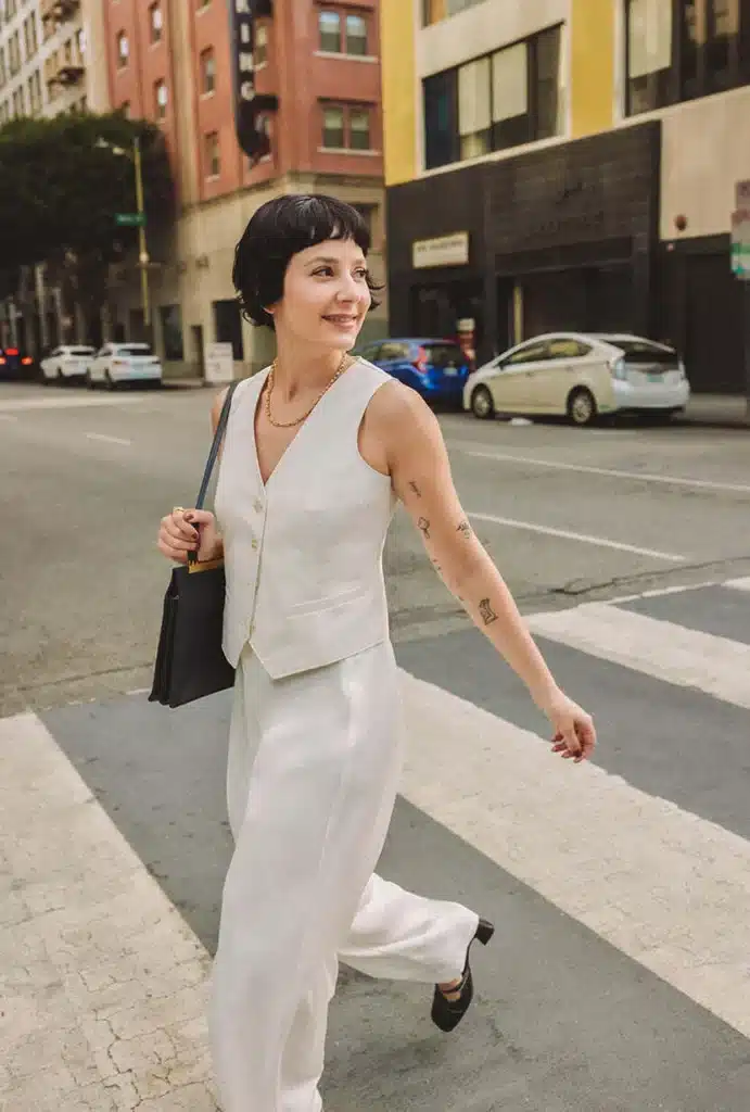 Woman walking across street in Ivory Vest from Petite Studio