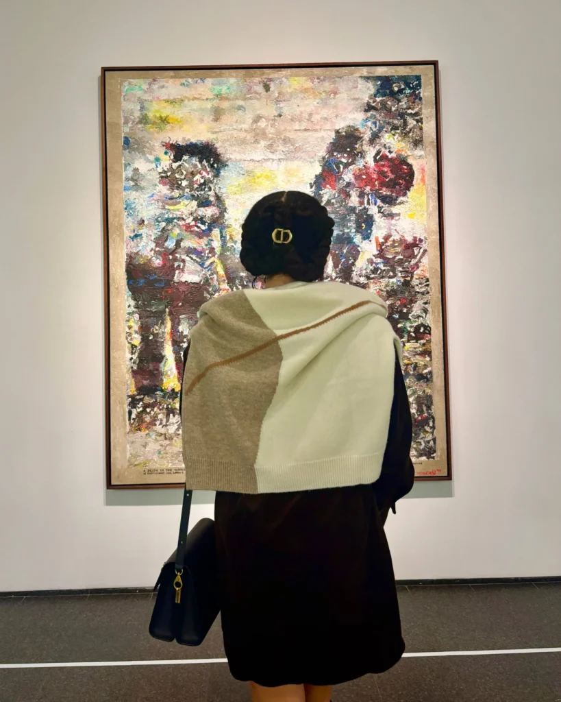 Elegant Woman in art gallery looking at oil painting 