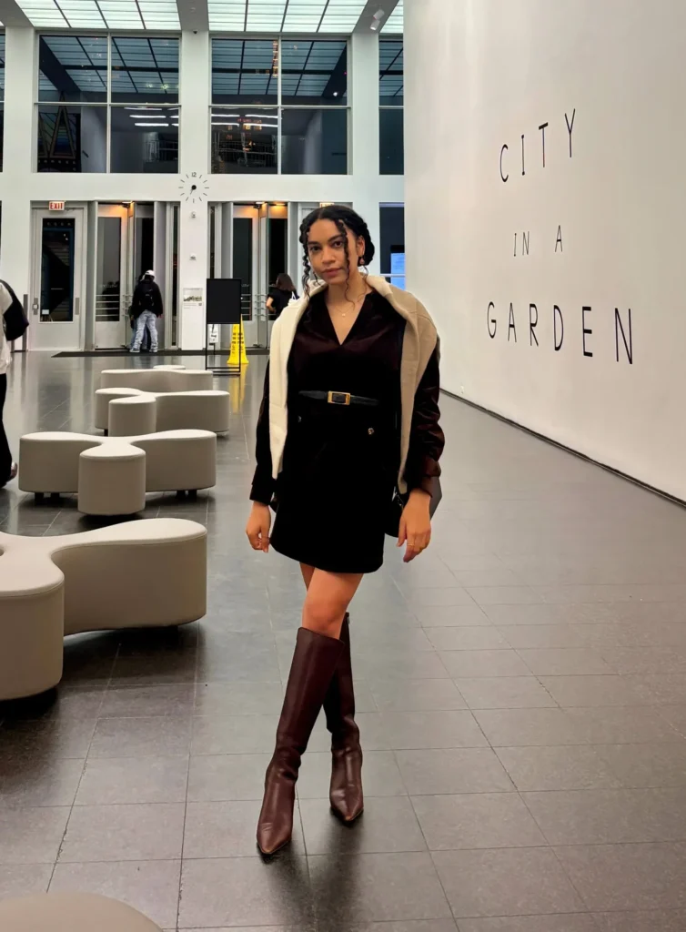 Woman in art gallery wearing elegant brown dress 
