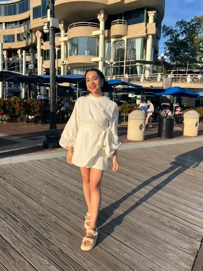 woman in ivory romper and woven platform espadrilles smiling at sunset