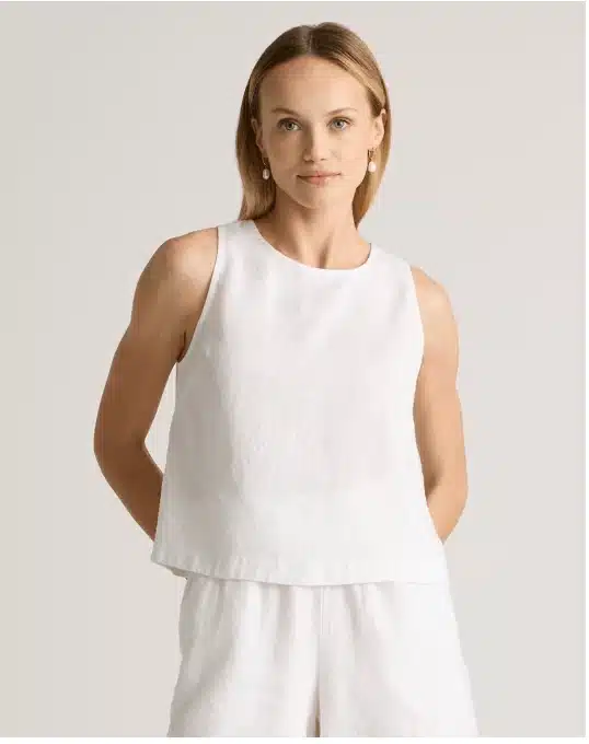 woman in white sleeveless linen tank top summer capsule wardrobe essential