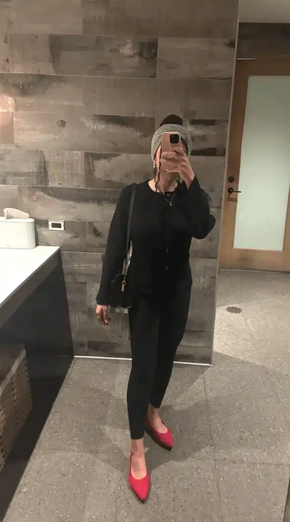 woman in cashmere cardigan, black pants, and red flats
