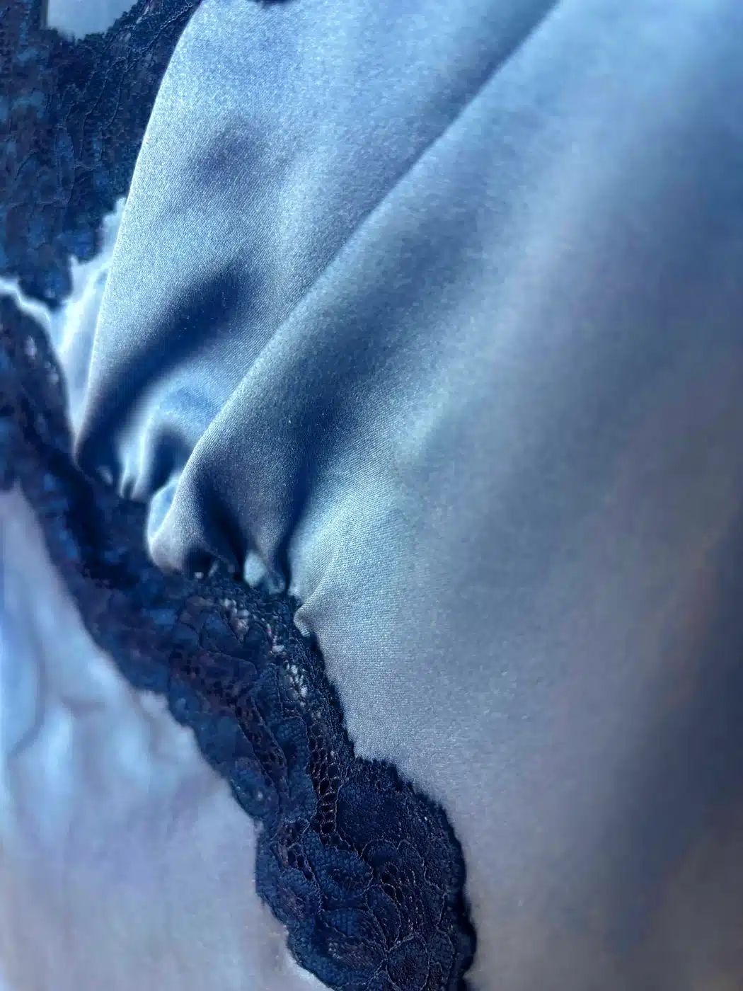 Close-up of blue Reformation Romi 19mm silk charmeuse showing its smooth sheen